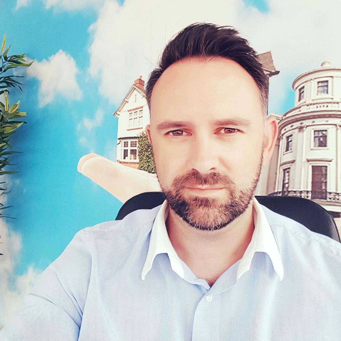 Paul in his estate agent office in front of a house mural